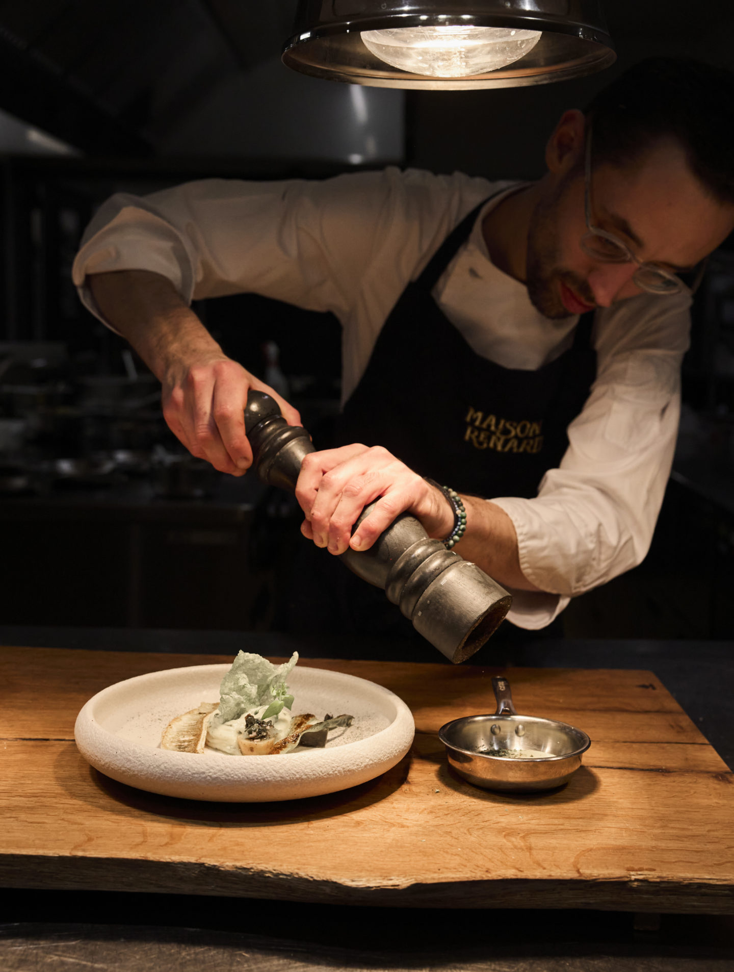 Dressage d'une assiette par un chef cuisinier dans une cuisine professionnelle