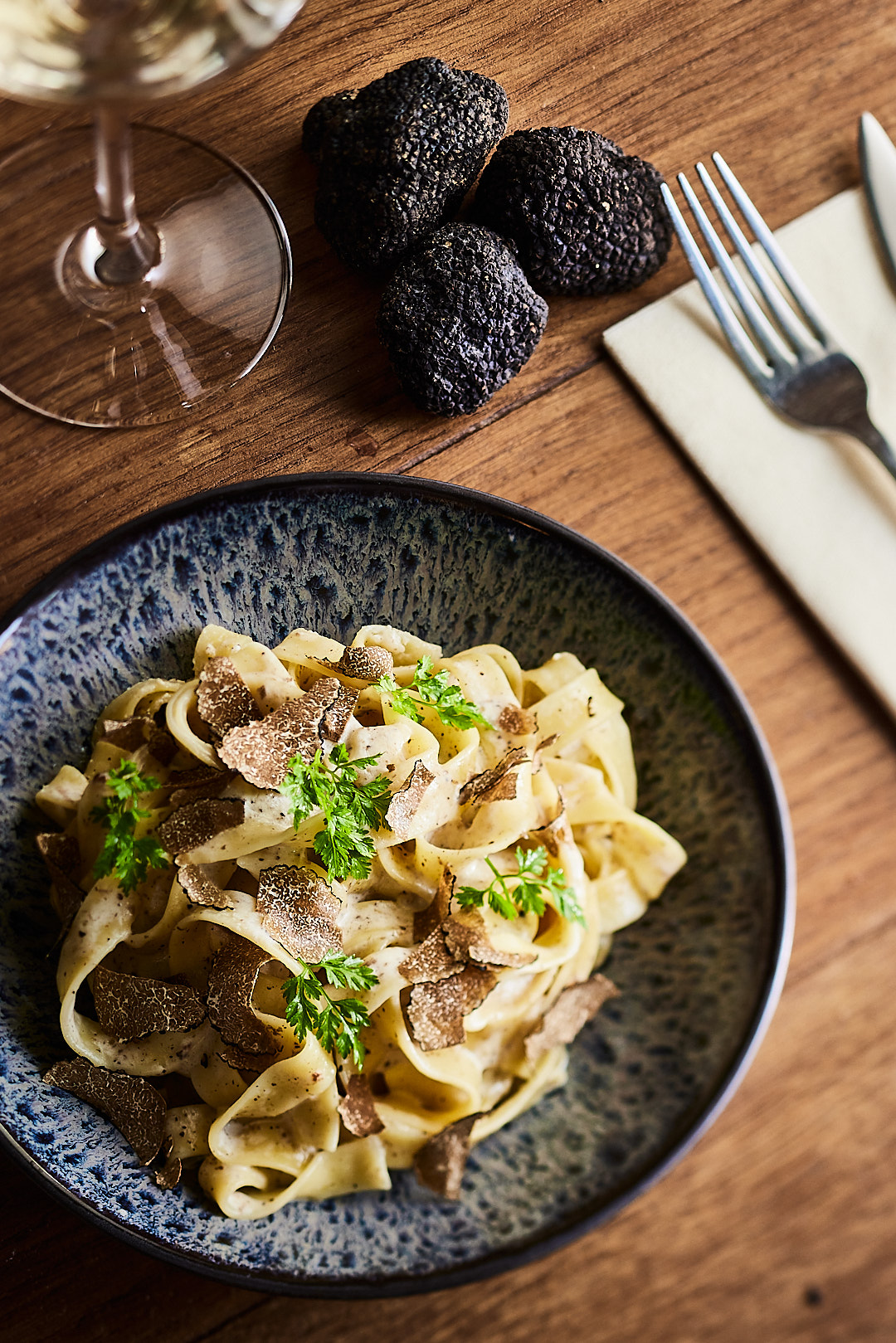Table dressée avec assiette de pâtes aux truffes