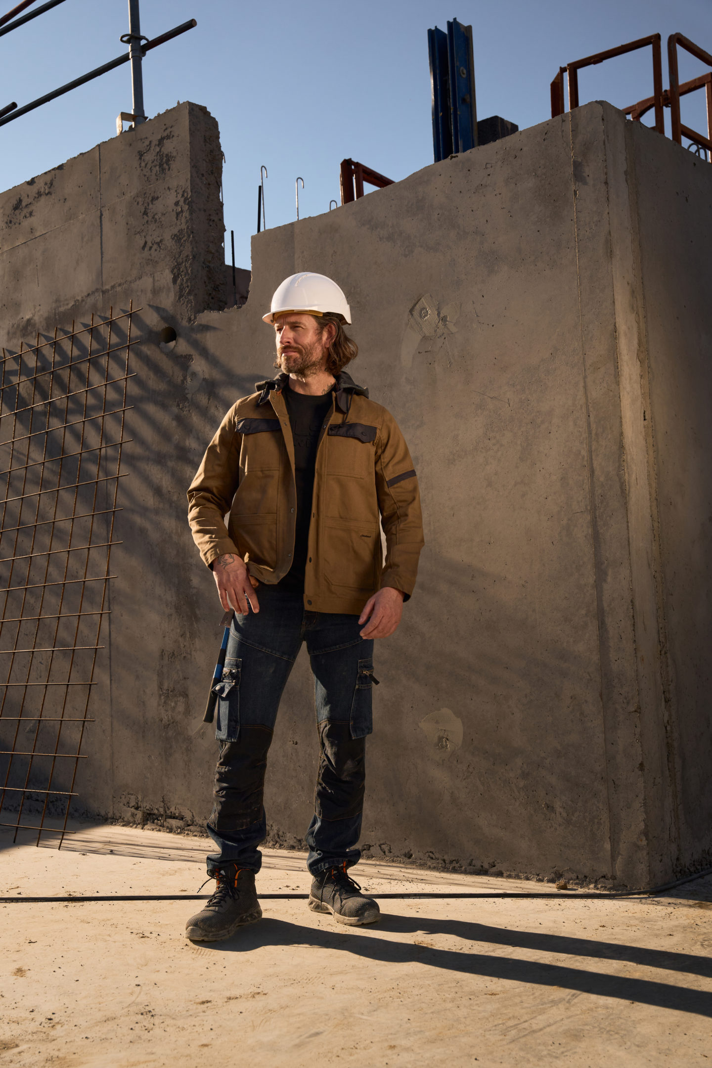 Homme en tenue Molinel avec un casque blanc au milieu d'un chantier
