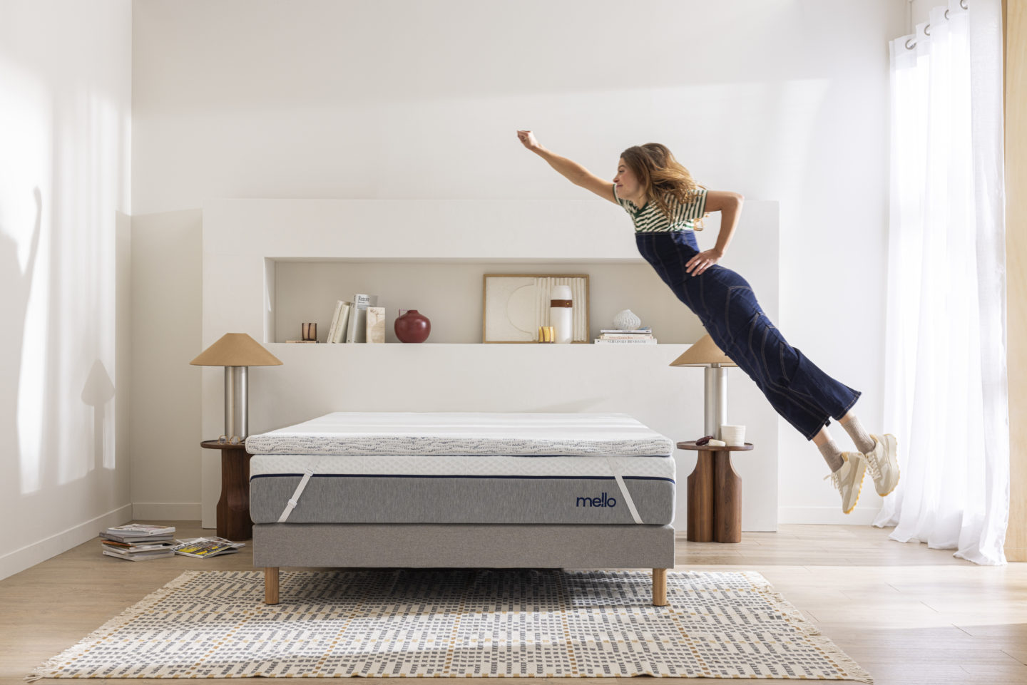 Une jeune femme saute sur son matelas en position superman