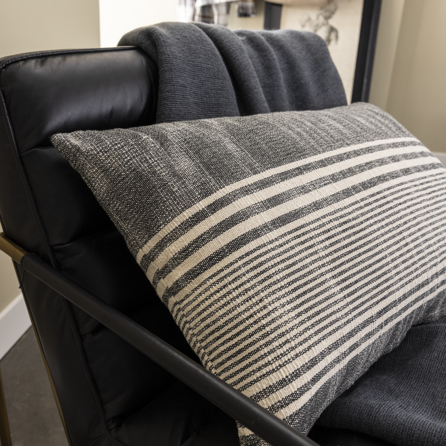 Focus coussin à rayures gris et blanc sur un fauteuil noir