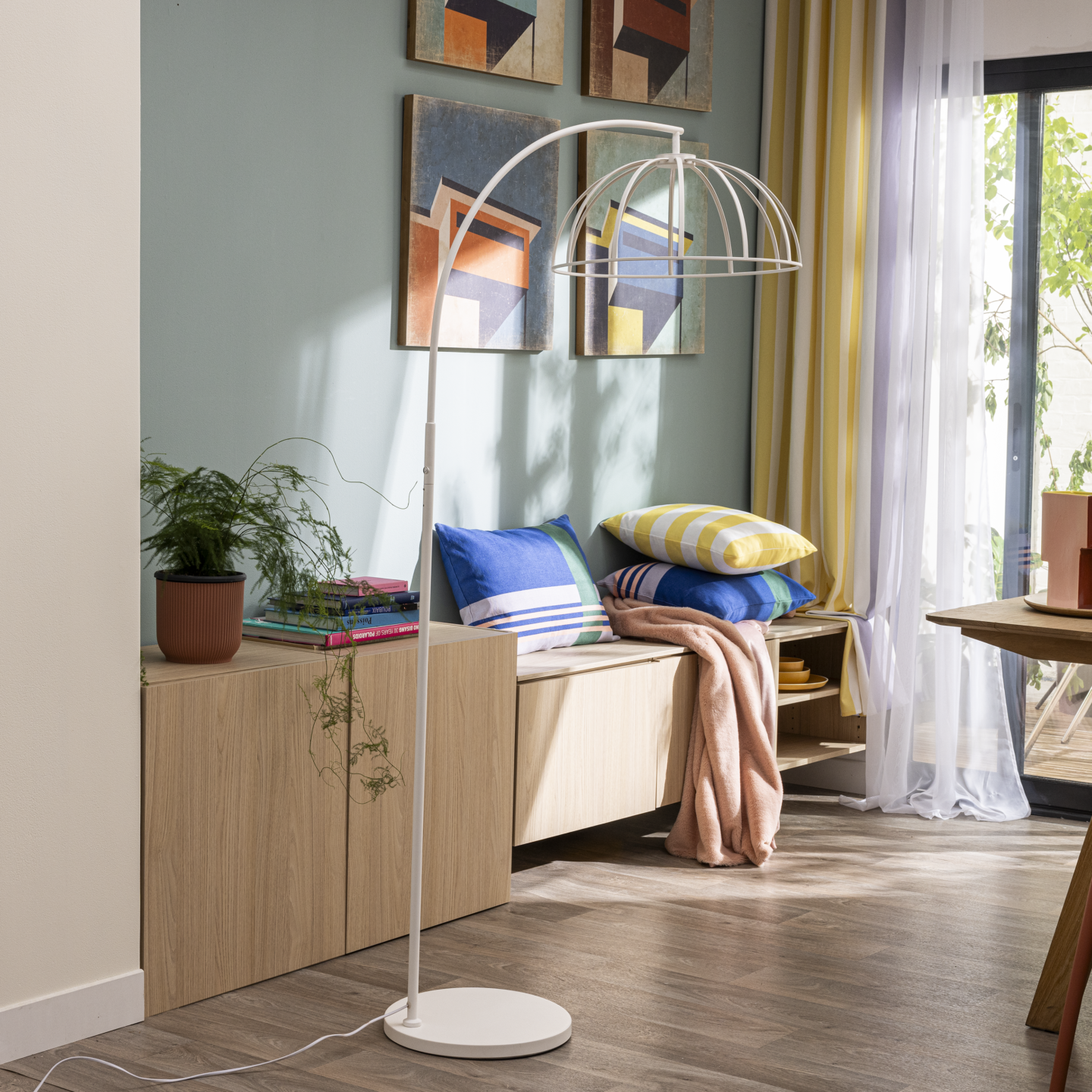 Salle à manger dans les teintes bleus, jaunes, blanches et bois avec un focus sur un lampadaire d'intérieur blanc