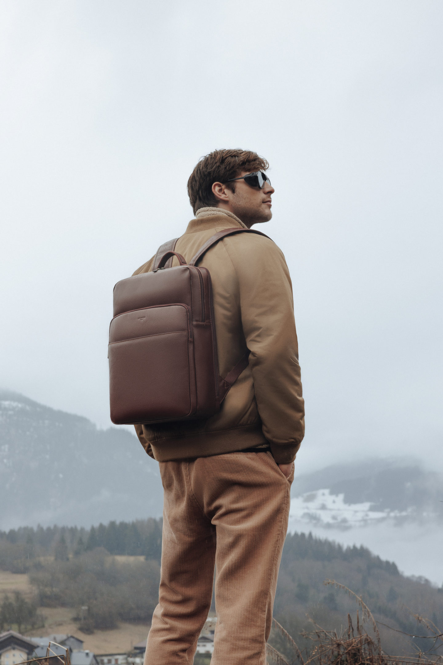 Homme portant un sac à dos hexagona avec un paysage montagneux en fond