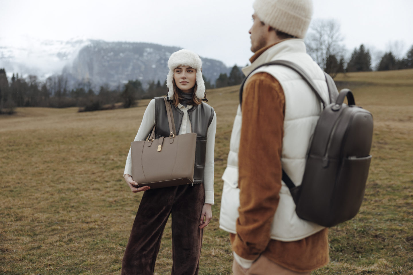Couple portant chacun un sac hexagona avec un paysage montagneux en fond