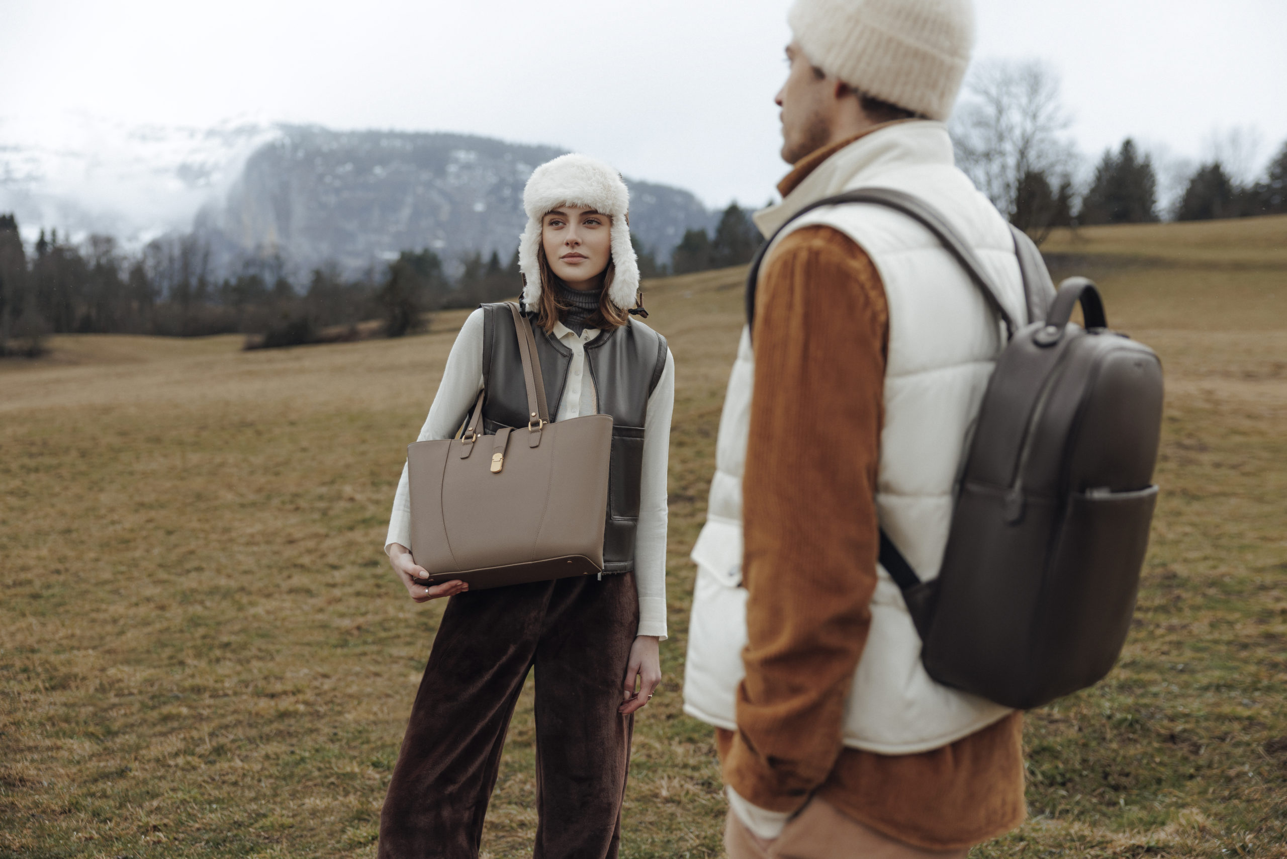 Couple portant chacun un sac hexagona avec un paysage montagneux en fond