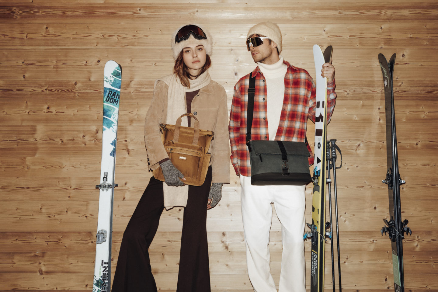 Couple avec skis et sacs hexagona dans un chalet