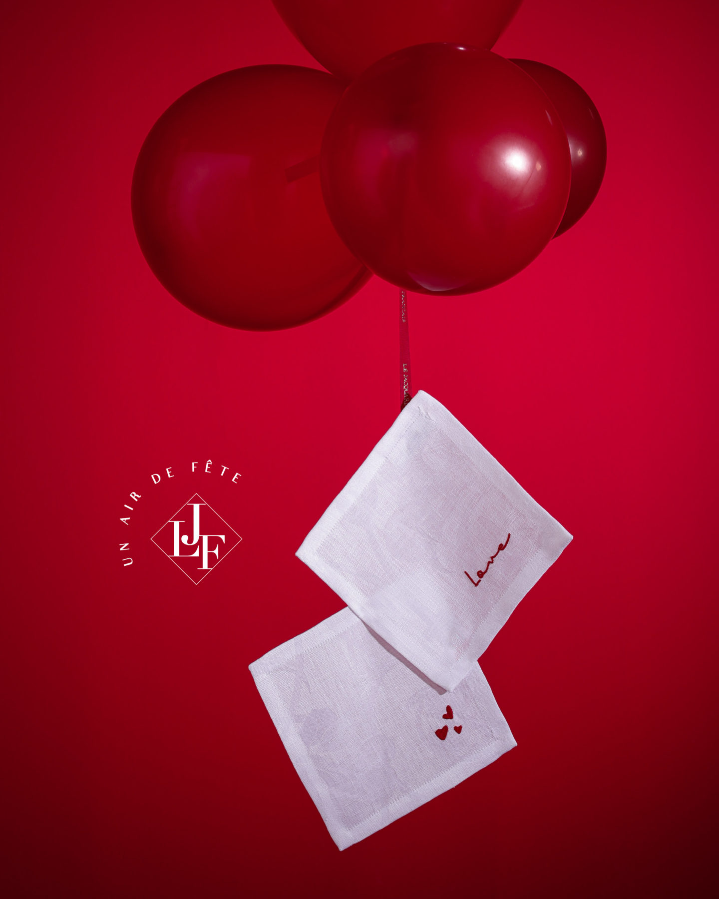 serviettes suspendus par un groupe de ballons rouges flottants