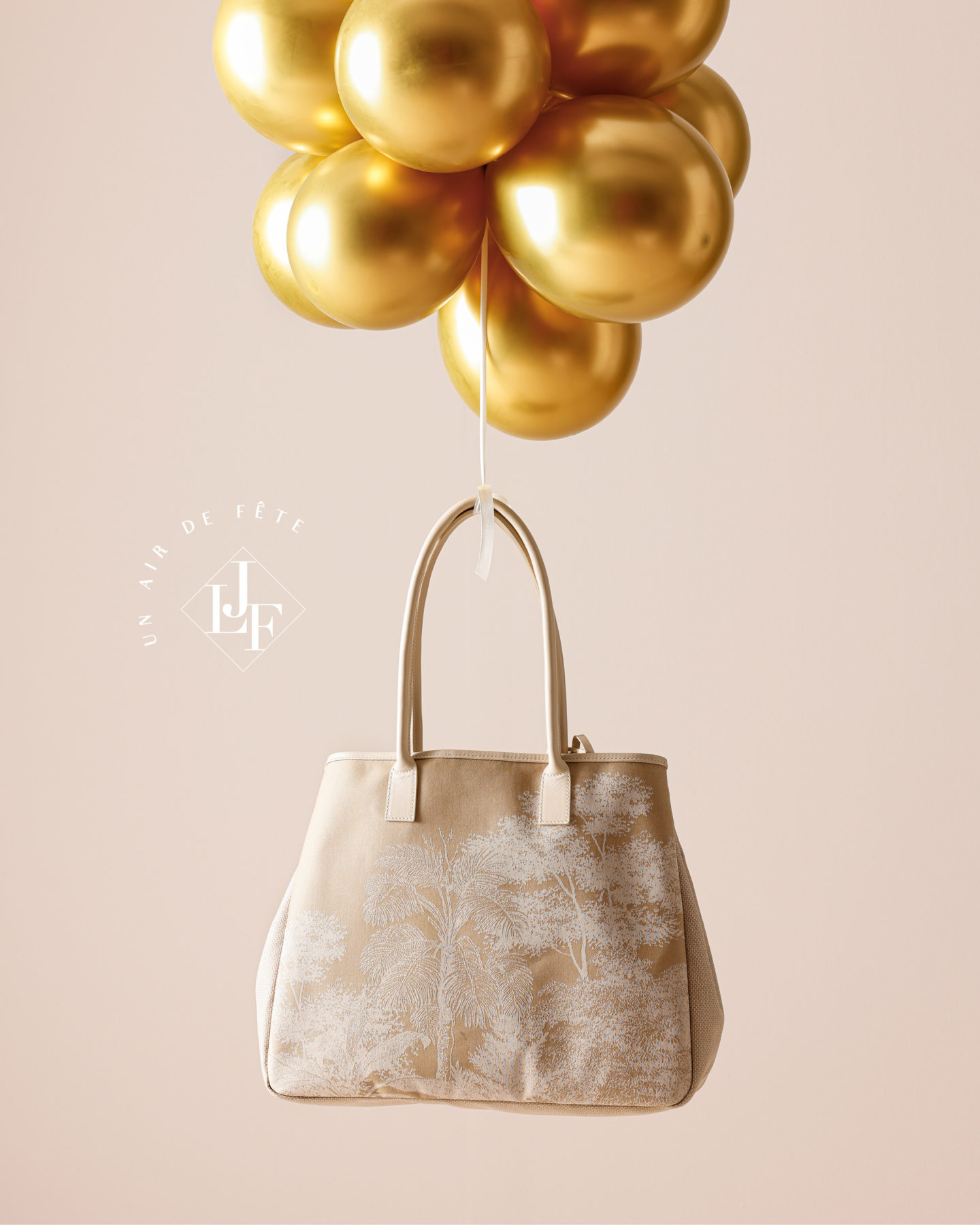 sac le jacquard français suspendu par un groupe de ballons dorés flottants