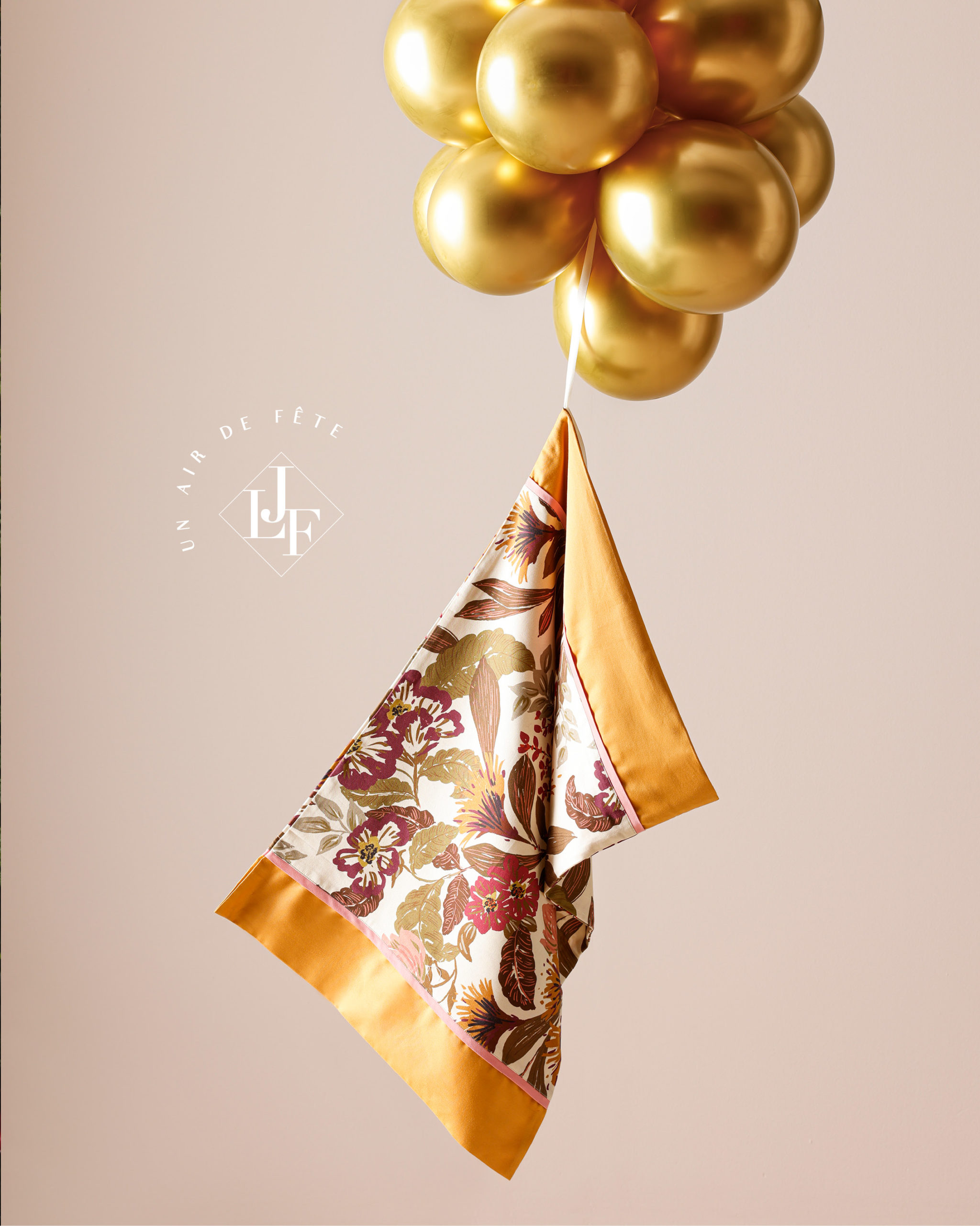 taie d'oreiller ocre suspendu par un groupe de ballons dorés flottants